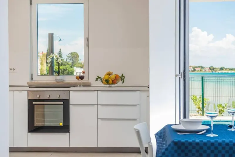 Villa Miri Privlaka Villa Miri Rosemary Kitchen shoot with appliances and blue kitchen table visible, view from the windows and terrace